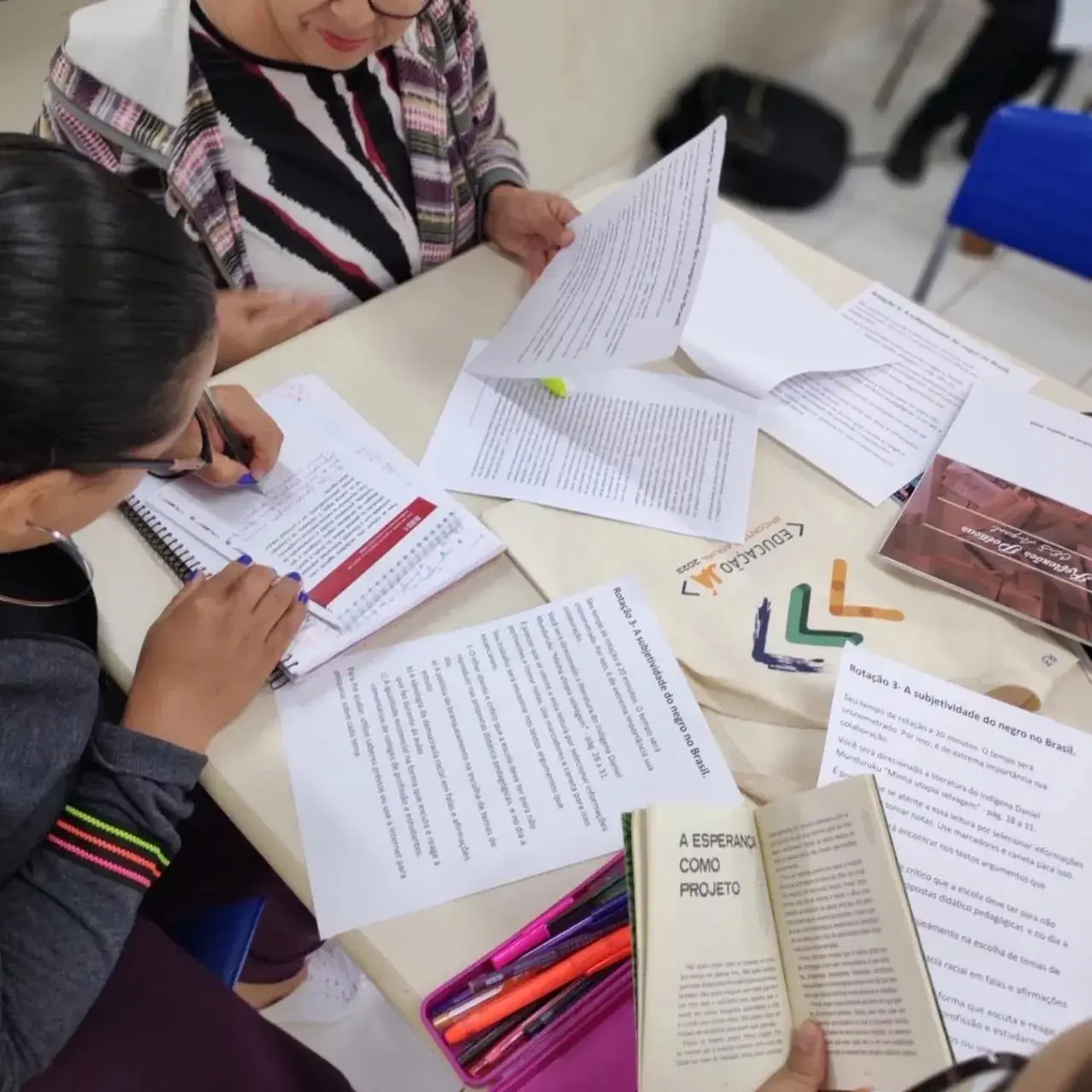 Professoras leem e anotam textos em uma rotação de estudo